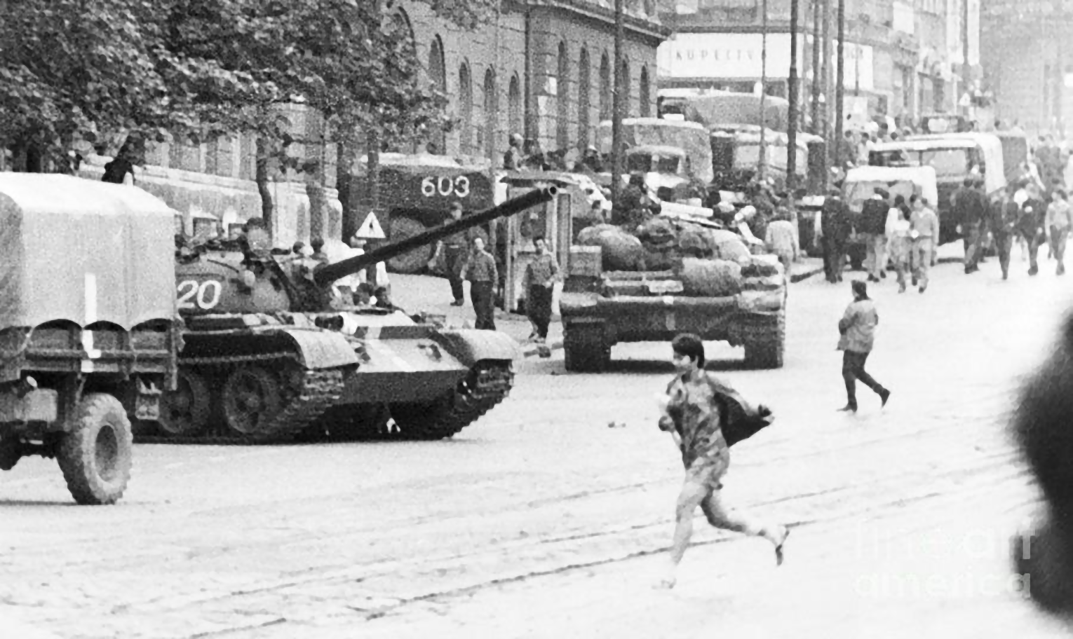 O tânără cehă alergând pentru a-și salva viața, în timp ce tancurile rusești deschid focul asupra demonstranților, 22 august 1968